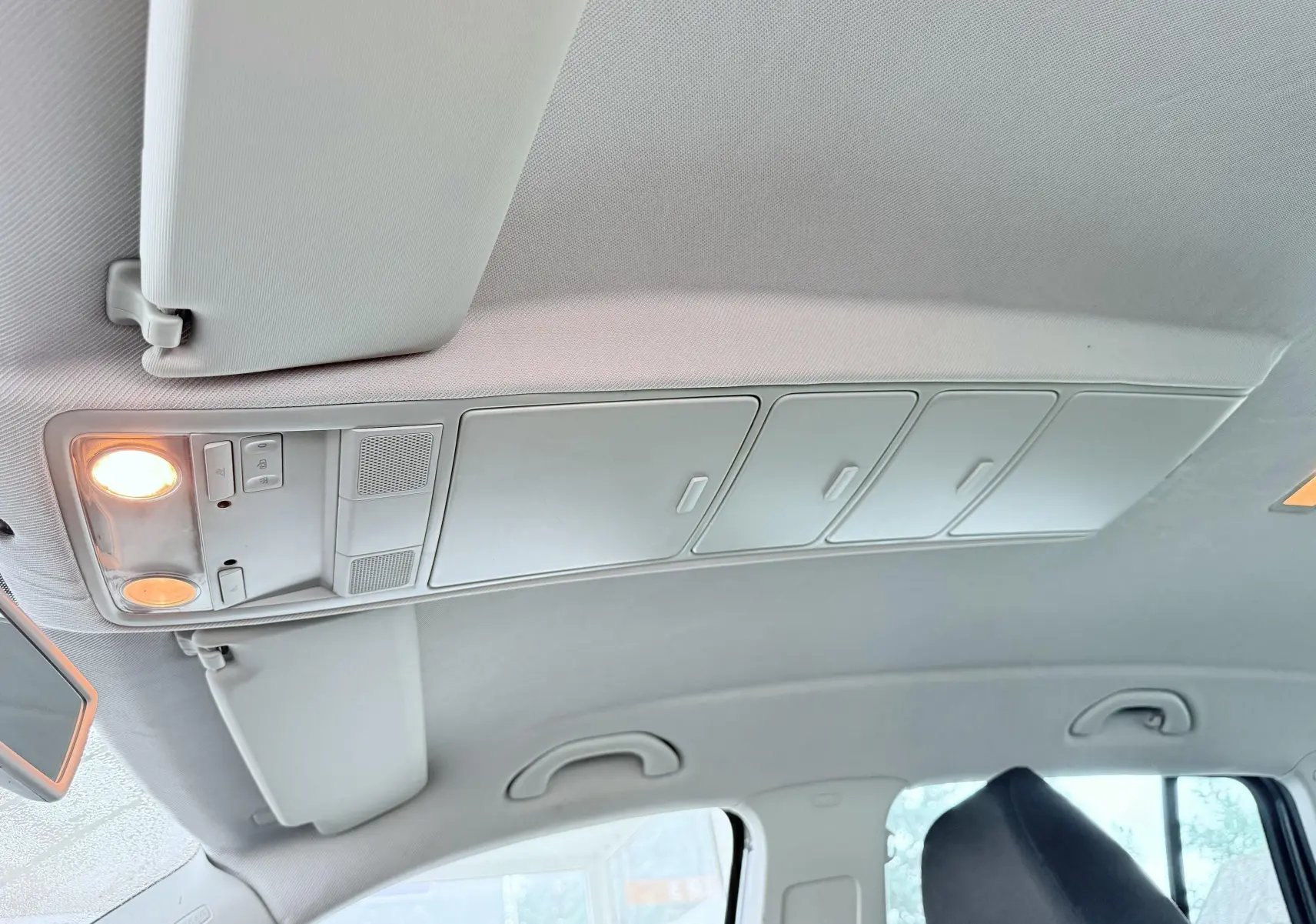Vue intérieure du plafond avec éclairage et rangements au-dessus des sièges avant d'un Volkswagen Tiguan noir.
