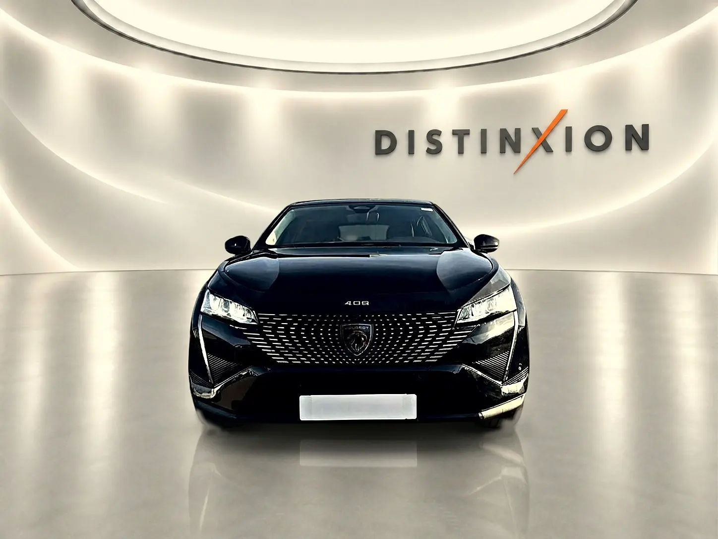 Vue frontale d'une Peugeot 408 noire 2025, avec calandre distinctive et phares LED allumés dans un showroom lumineux.