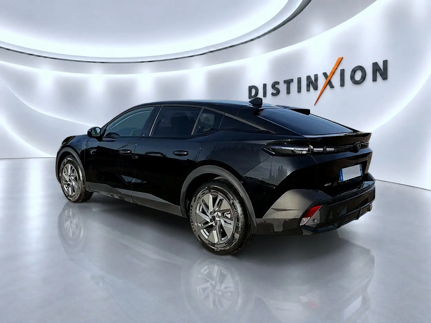 Peugeot 408 Hybrid 145 allure e-dcs6 noir, vue 3/4 arrière droit dans un showroom lumineux avec logo Distinxion.