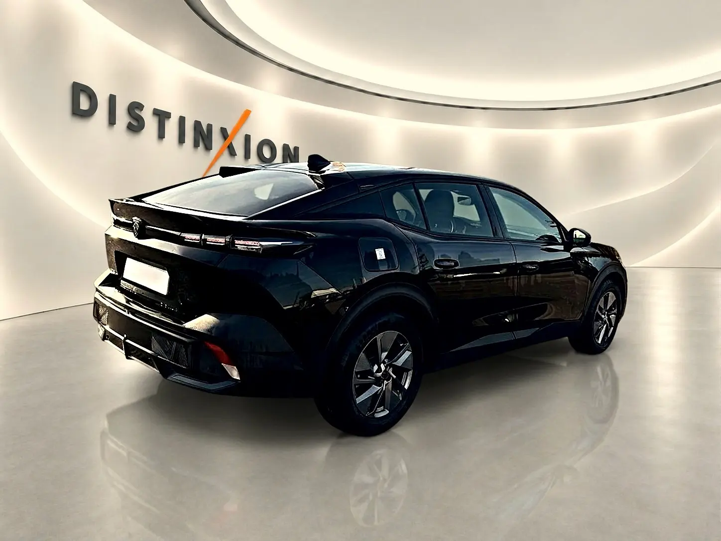 Vue 3/4 arrière droite d'une Peugeot 408 Hybrid 145 noire avec jantes alu et feux arrière LED distinctifs.