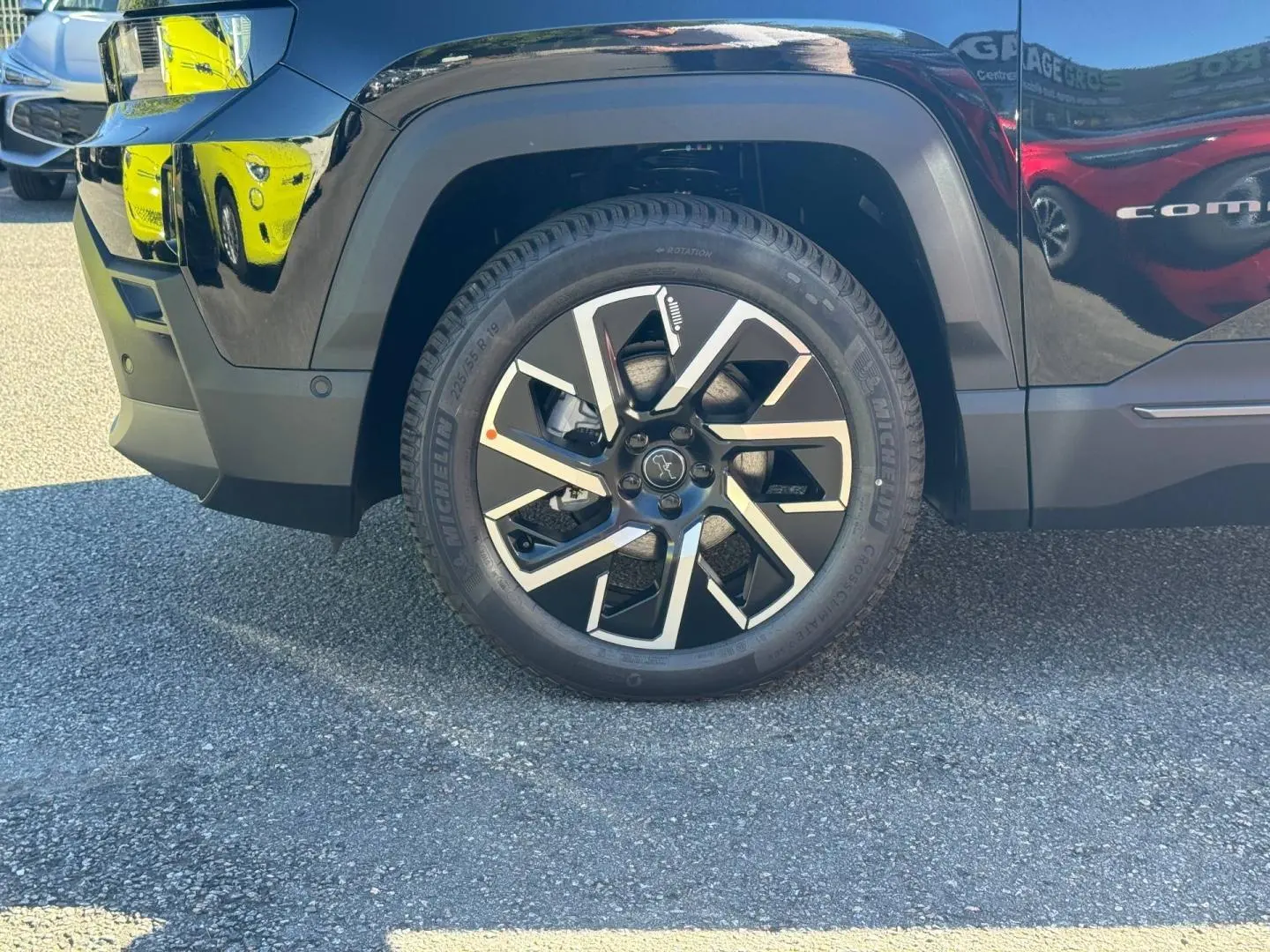 Gros plan sur la roue avant gauche du Jeep Compass Vulcano noire, avec jante alu bicolore et pneu Michelin.