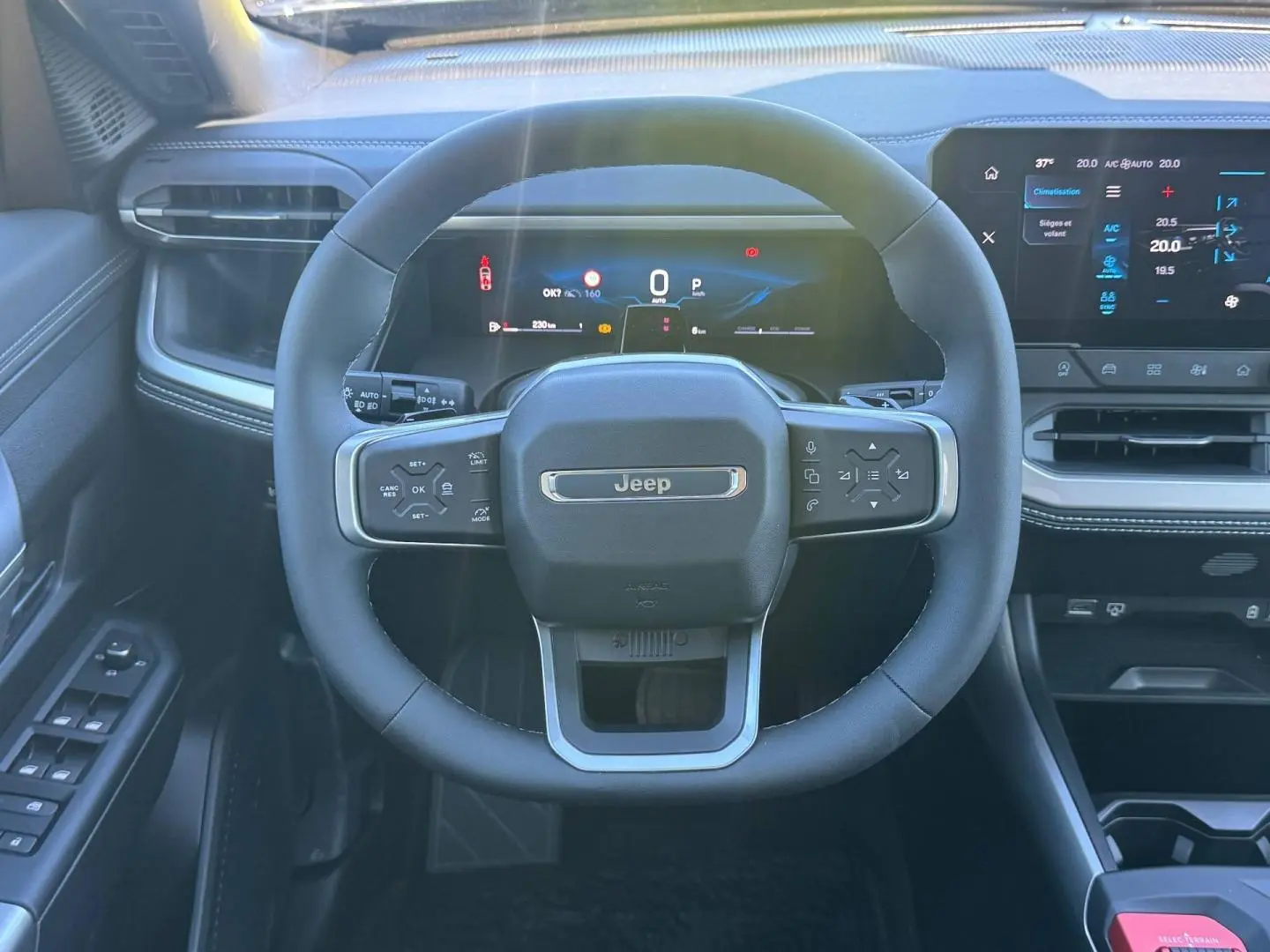 Vue frontale du volant Jeep Compass 2026 avec tableau de bord numérique et écran tactile, intérieur noir et gris anthracite.