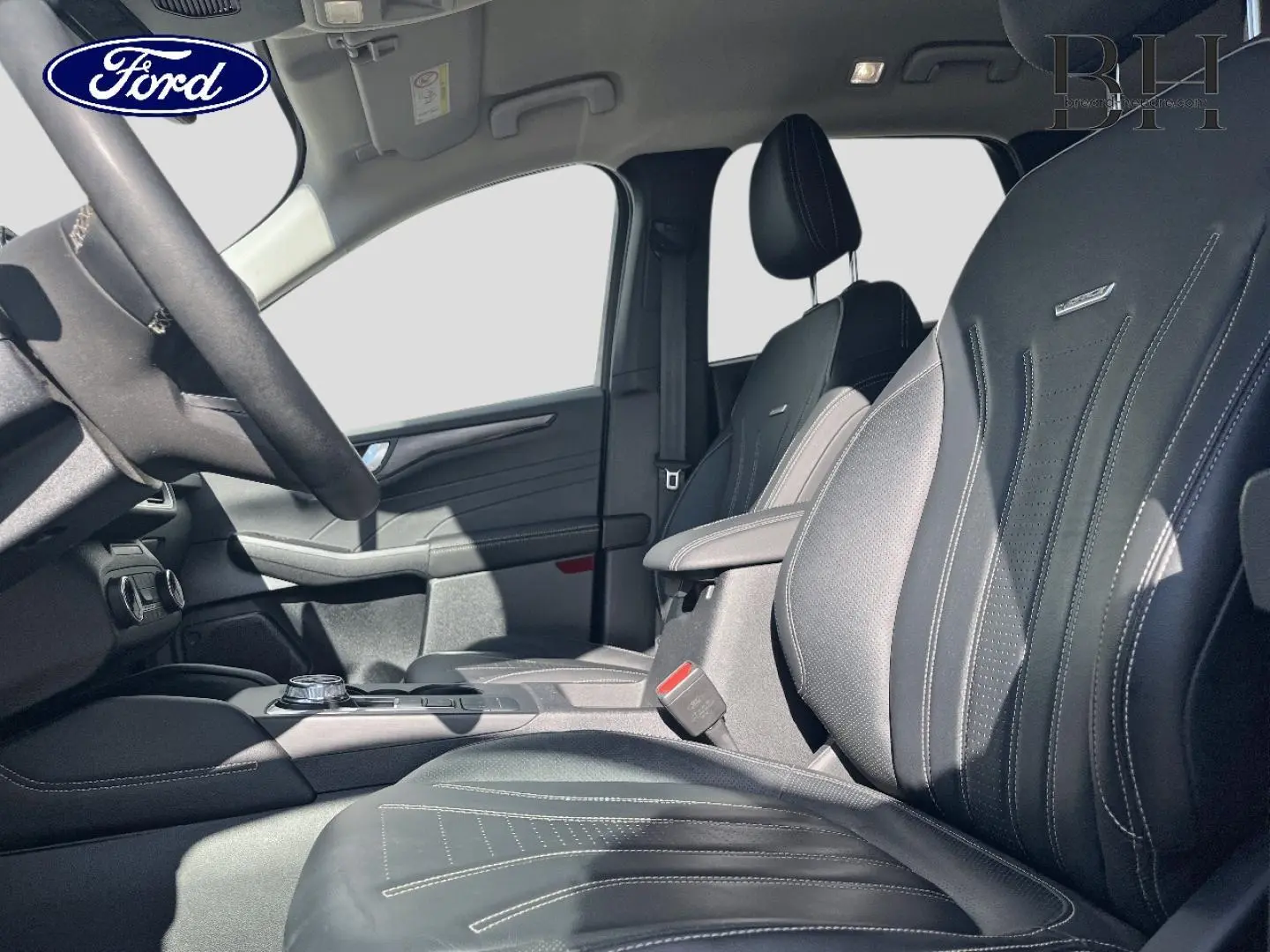 Intérieur avant du Ford Kuga 2023, vue côté gauche, sièges en cuir noir Windson avec surpiqûres contrastantes.