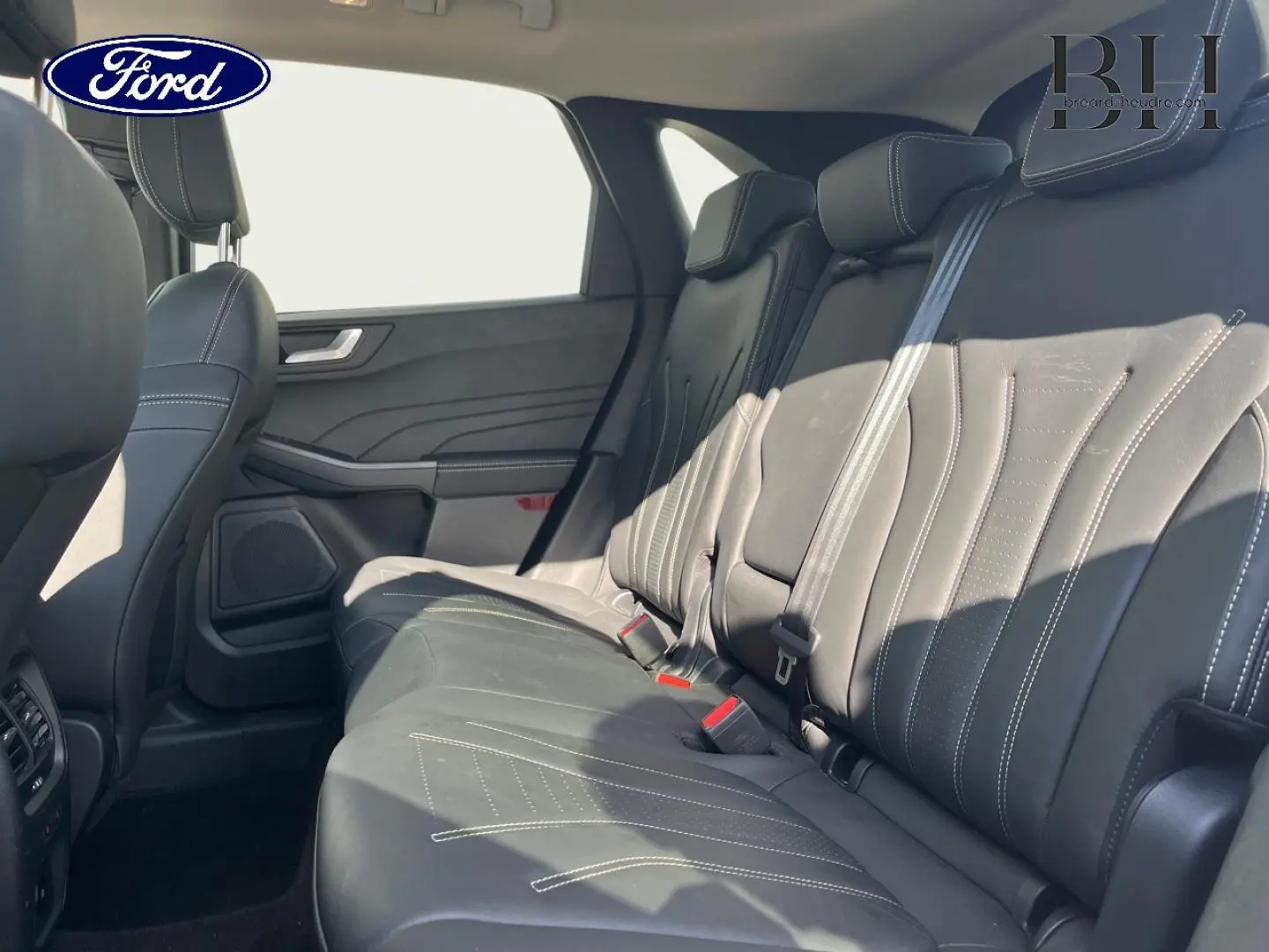 Vue latérale droite de la banquette arrière en cuir noir du Ford Kuga 2023 avec ceintures et appuie-têtes visibles.