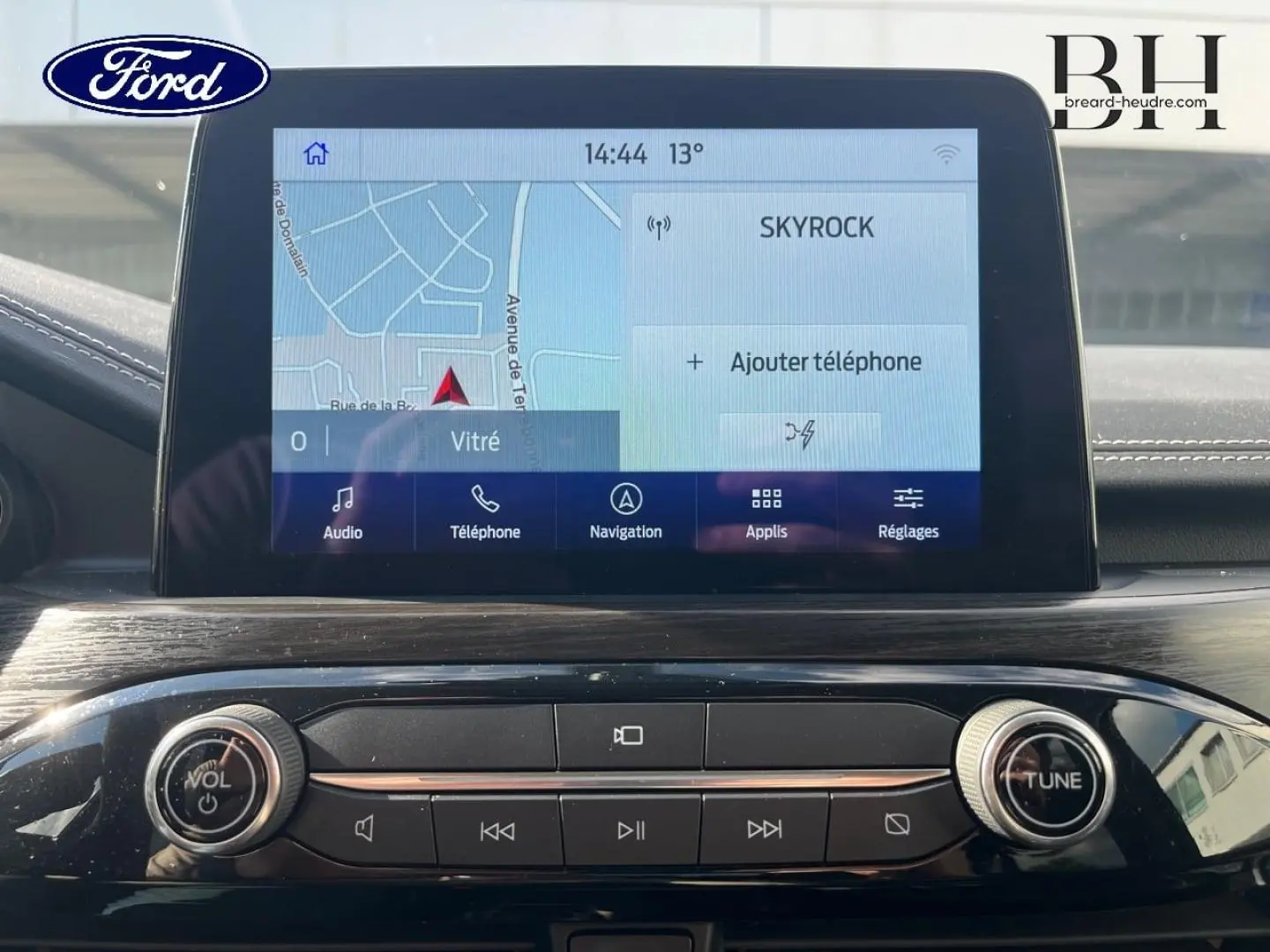 Vue rapprochée de l'écran tactile multifonction et de la console centrale noire brillante du Ford Kuga 2023.