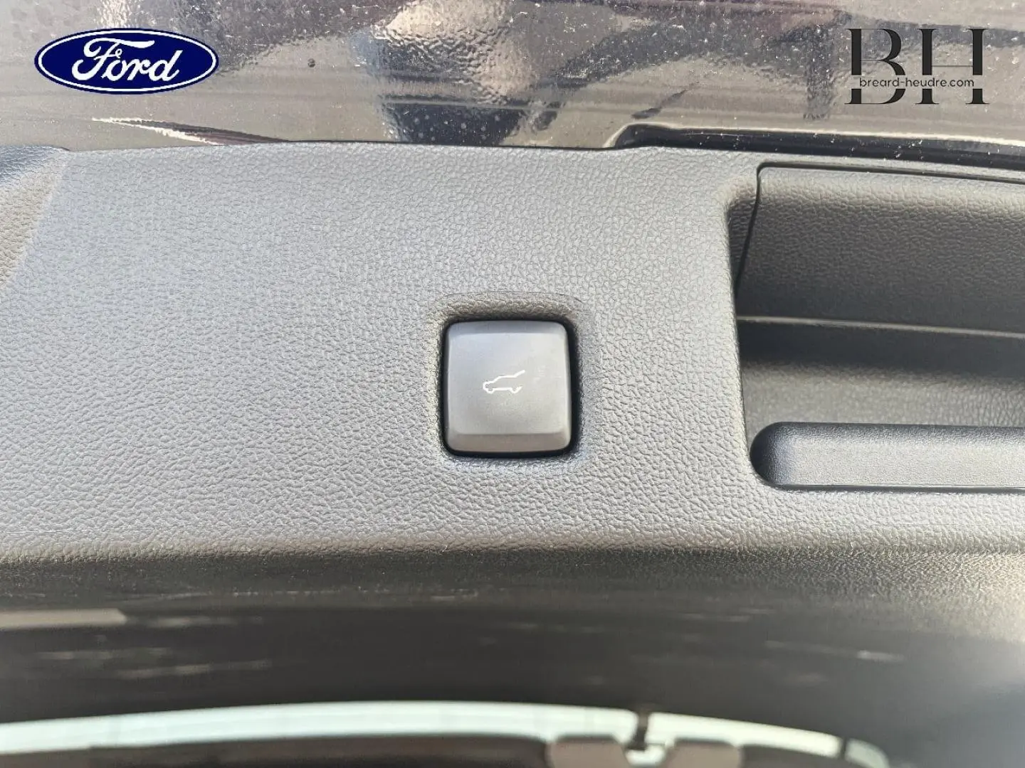 Bouton d'ouverture électrique du coffre sur la garniture intérieure noire du Ford Kuga 2023 Noir Agate Métallisée.
