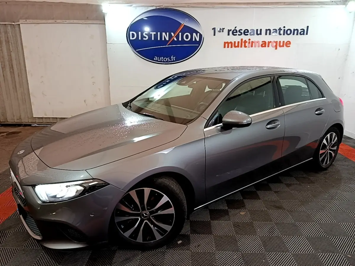 Mercedes Classe A 180 d Business Line gris foncé vue 3/4 avant droit, phares LED allumés et jantes distinctives.