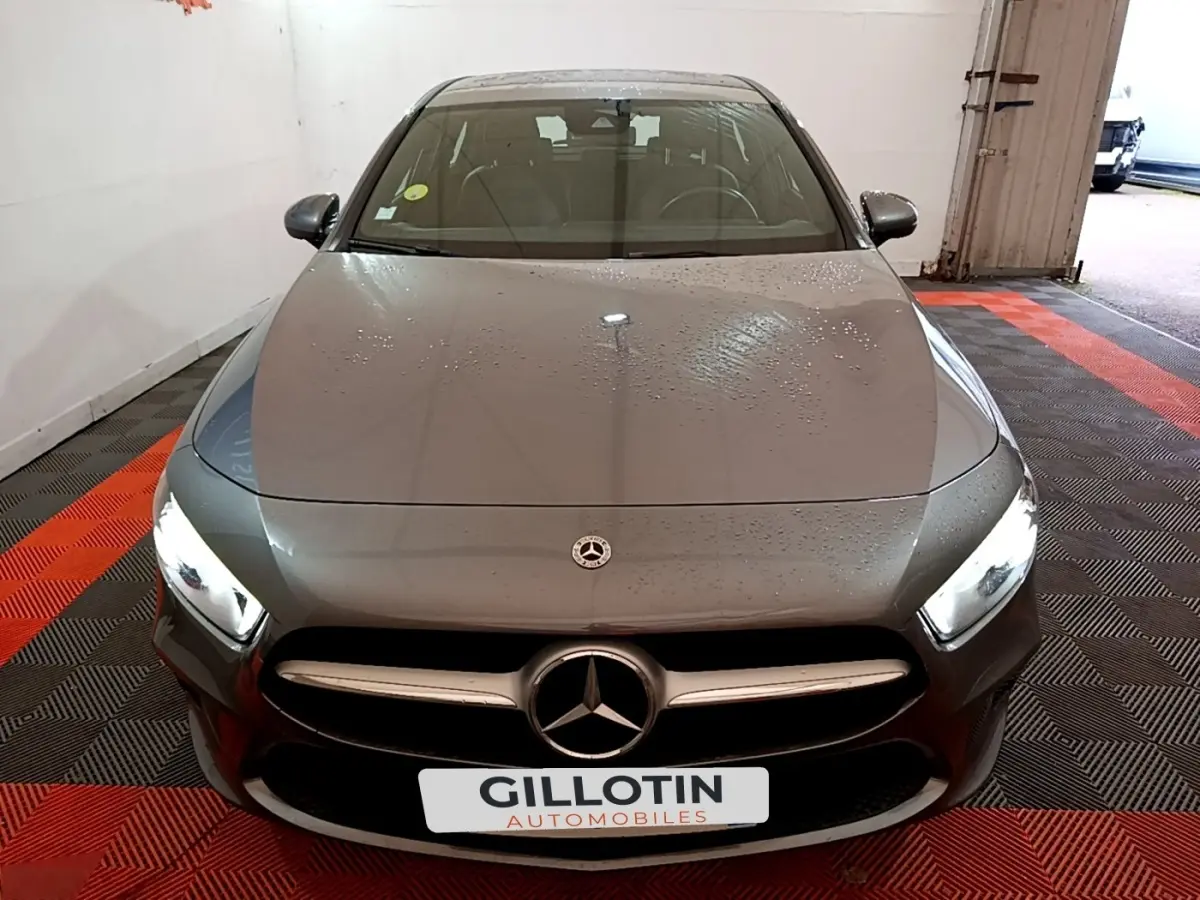 Vue avant d'une Mercedes Classe A 180 d Business Line gris foncé avec phares LED allumés dans un garage.