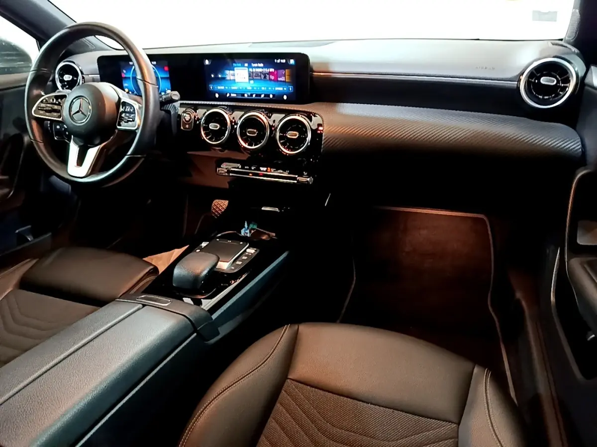 Vue intérieure côté conducteur de la Mercedes Classe A 180 d Business Line 2021 avec volant cuir et écran tactile double.