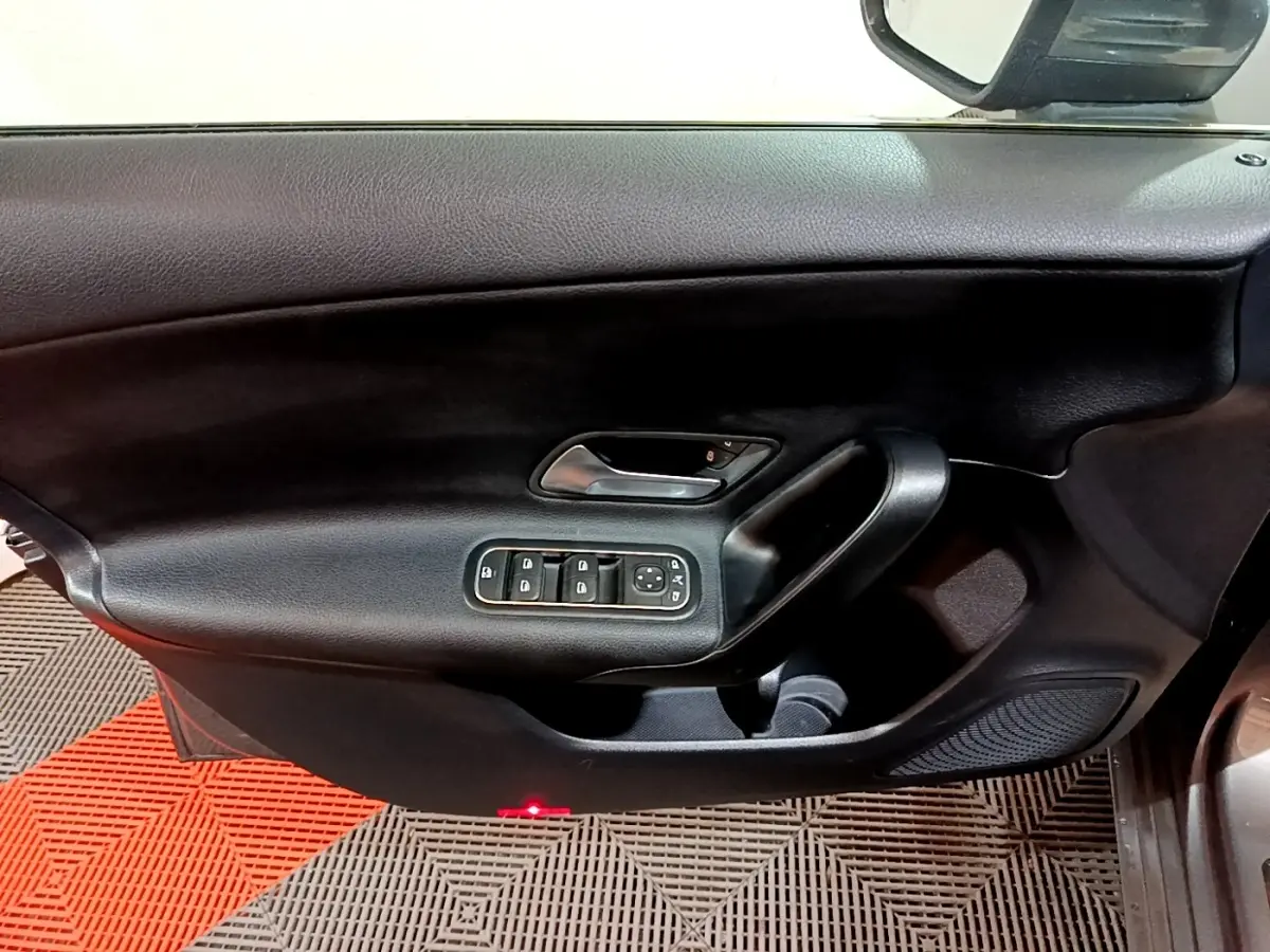 Vue rapprochée de la porte avant gauche noire avec commandes électriques des vitres et rétroviseur d'une Mercedes Classe A 180 d.