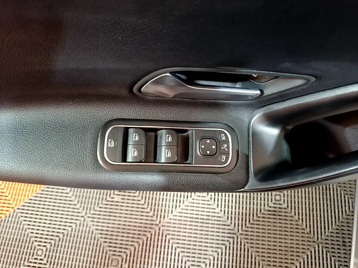 Gros plan sur la porte intérieure côté conducteur de la Mercedes Classe A 180 d Business Line avec commandes de vitres et poignée noire.