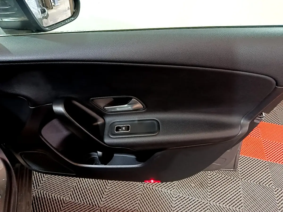 Vue intérieure côté gauche de la porte d’une Mercedes Classe A 180 d Business Line 2021 avec garniture noire et poignée argentée.