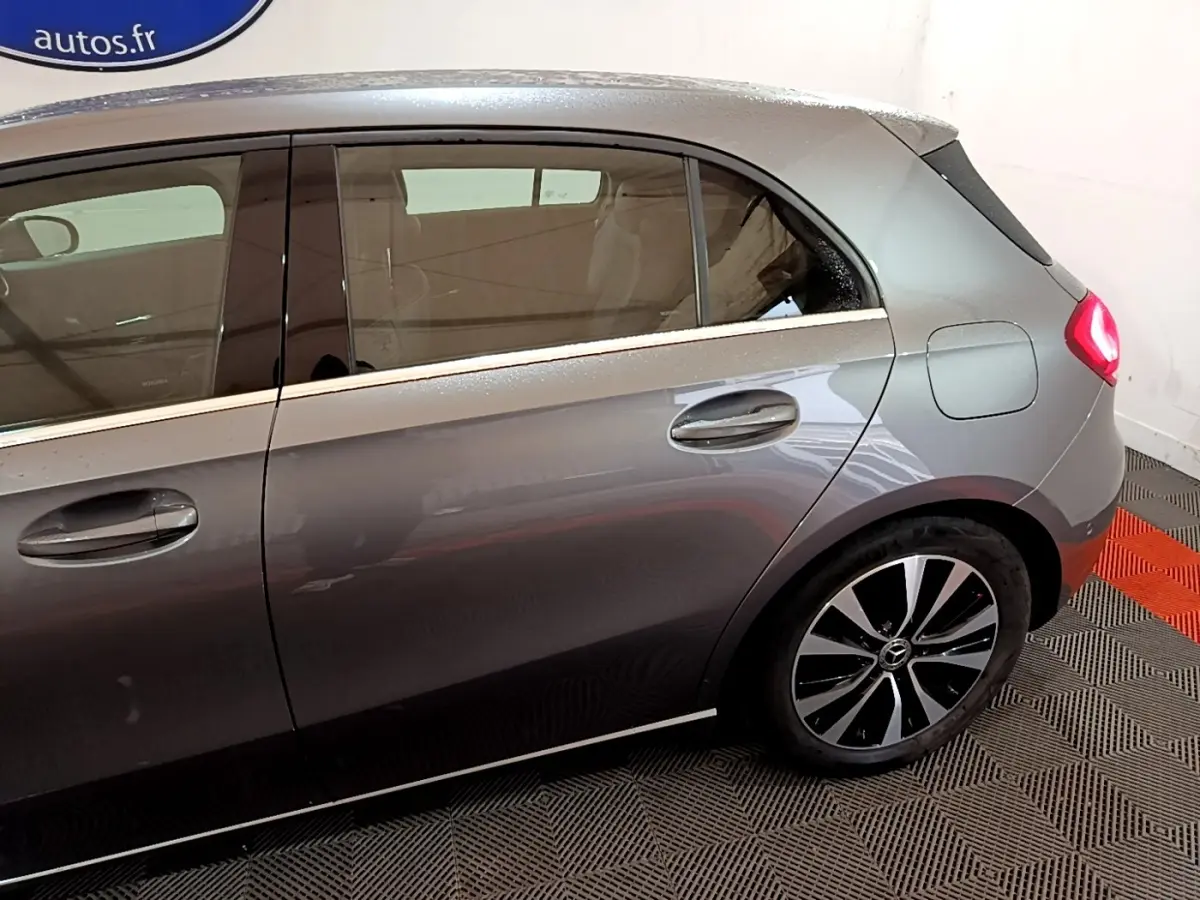 Vue latérale droite d'une Mercedes Classe A gris foncé, mettant en valeur les jantes alliage et les poignées de porte.