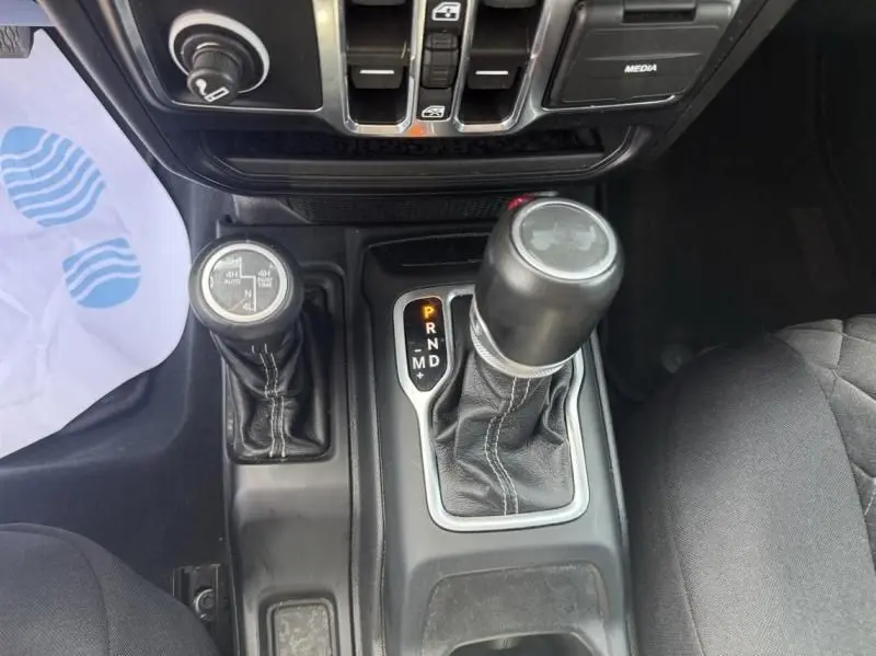 Vue rapprochée de la console centrale noire du Jeep Wrangler 2022 avec leviers de vitesses automatique et 4x4 visibles.