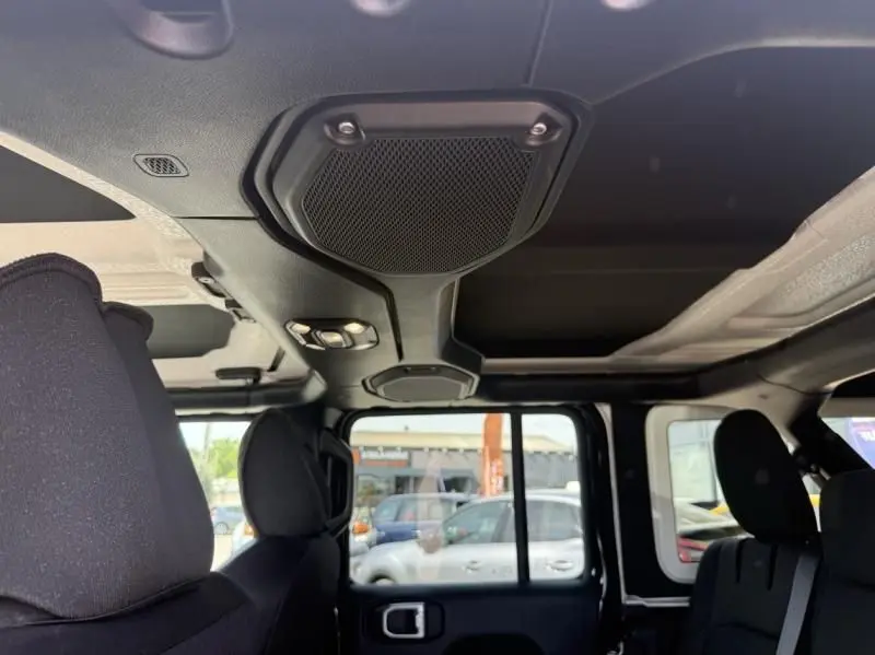 Vue intérieure du toit et des sièges noirs du Jeep Wrangler Unlimited 2022, avec haut-parleur et éclairage intégrés.