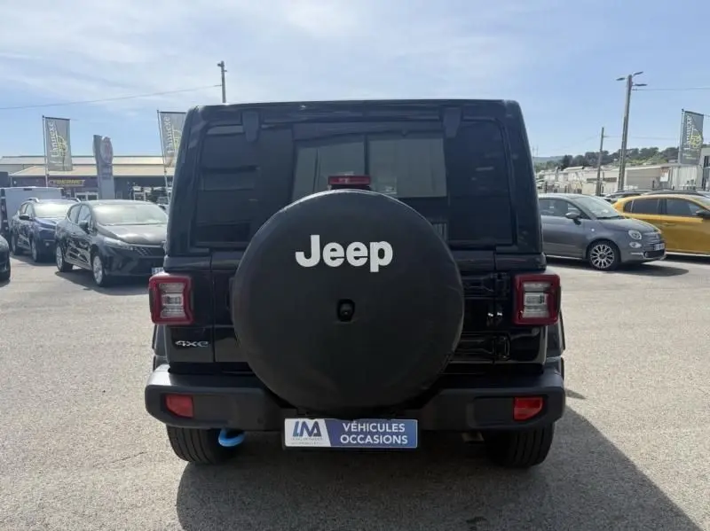 Vue arrière d’un Jeep Wrangler noir 2022 avec roue de secours couverte et logo Jeep bien visible.