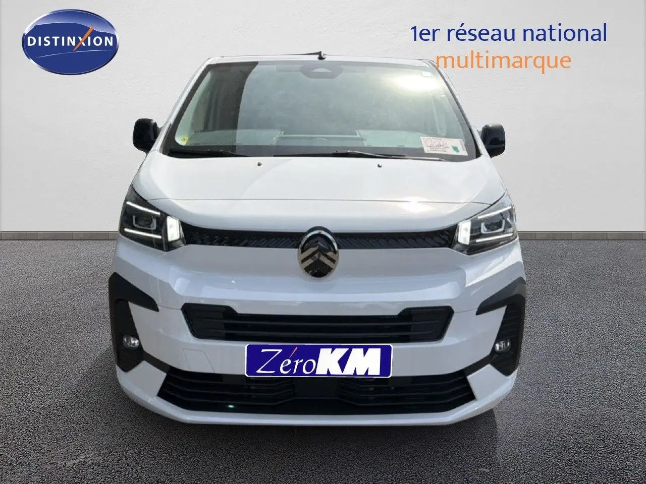 Vue de face du Citroën Jumpy blanc Kaolin avec calandre noire et feux LED distinctifs allumés.