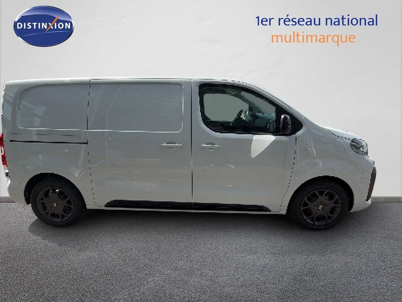 Profil droit d’un Citroën Jumpy blanc Kaolin, fourgon utilitaire avec jantes noires et vitres teintées à l’avant.