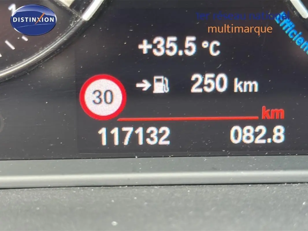 Affichage numérique du tableau de bord de la BMW X2 blanc montrant la température, autonomie et kilométrage.