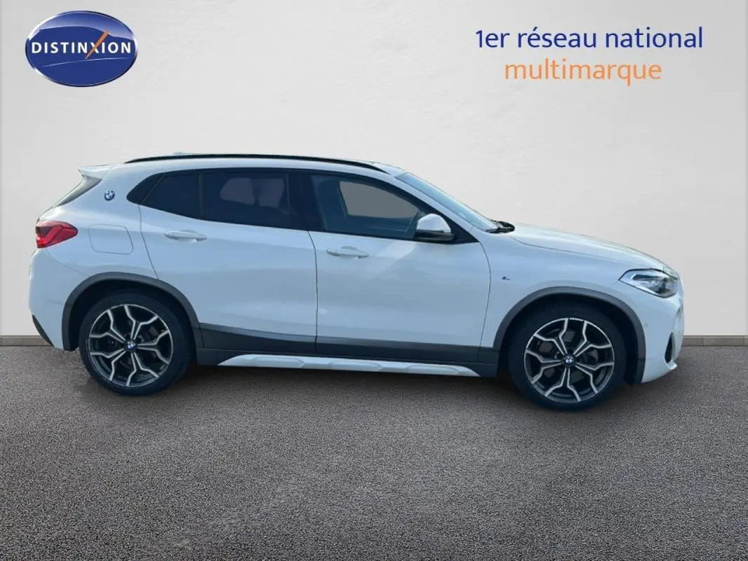 Profil droit d’un BMW X2 blanc 2018 avec jantes alliage 19 pouces et toit ouvrant panoramique visible.