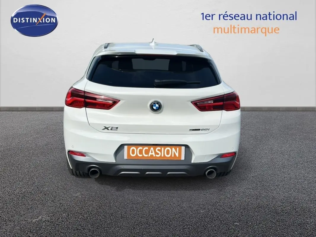 Vue arrière d’un BMW X2 blanc F39 sDrive 20i 2018 avec double sortie d’échappement et feux rouges distinctifs.