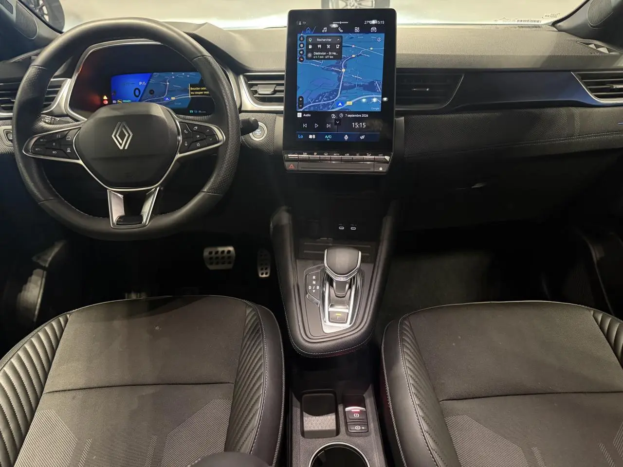 Vue intérieure avant de la Renault SYMBIOZ 1.6 E-Tech Hybride avec tableau de bord numérique et écran tactile vertical.