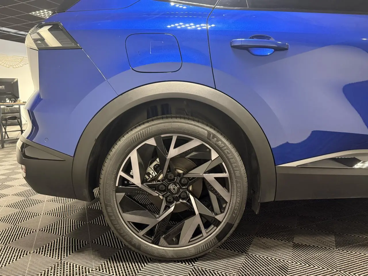 Gros plan sur la roue arrière droite bleue Renault Symbioz 2025 avec jante aluminium 19 pouces Elixir.
