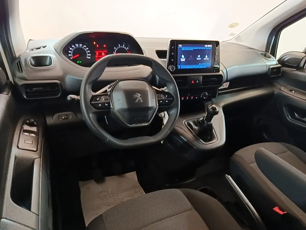 Intérieur du Peugeot Partner 2020 vu de face, tableau de bord noir avec volant compact et écran tactile central.