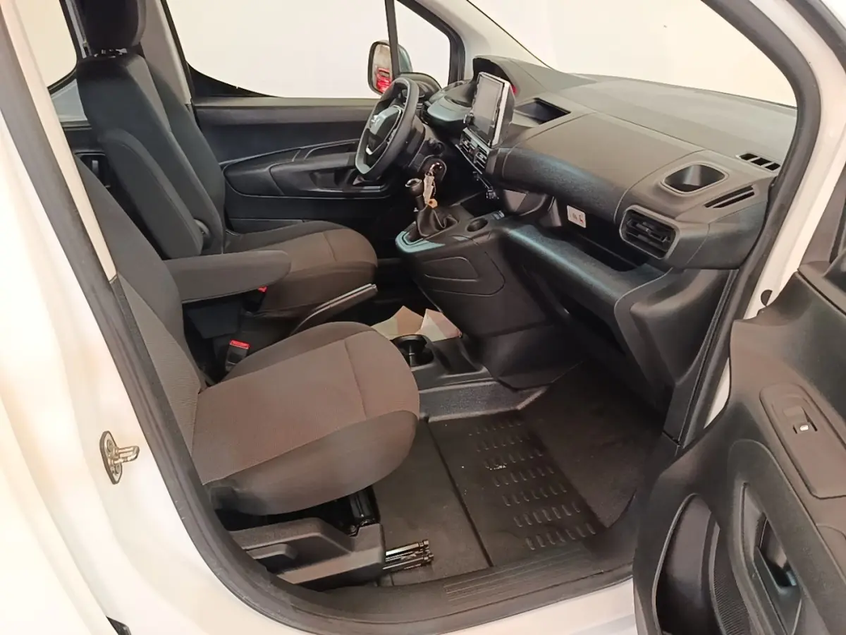Vue intérieure côté conducteur du Peugeot Partner blanc 2020, montrant les sièges avant et le tableau de bord moderne.