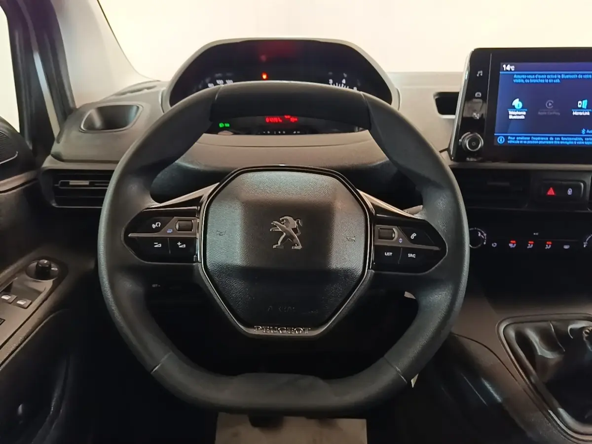 Vue intérieure centrée sur le volant noir du Peugeot Partner 2020 avec tableau de bord et écran tactile à droite.