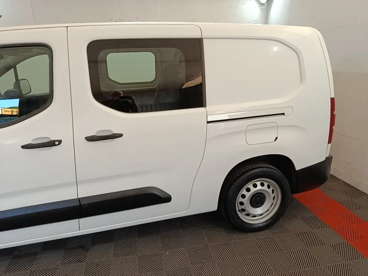 Vue latérale droite du Peugeot Partner blanc 2020 avec cabine allongée et porte latérale vitrée.