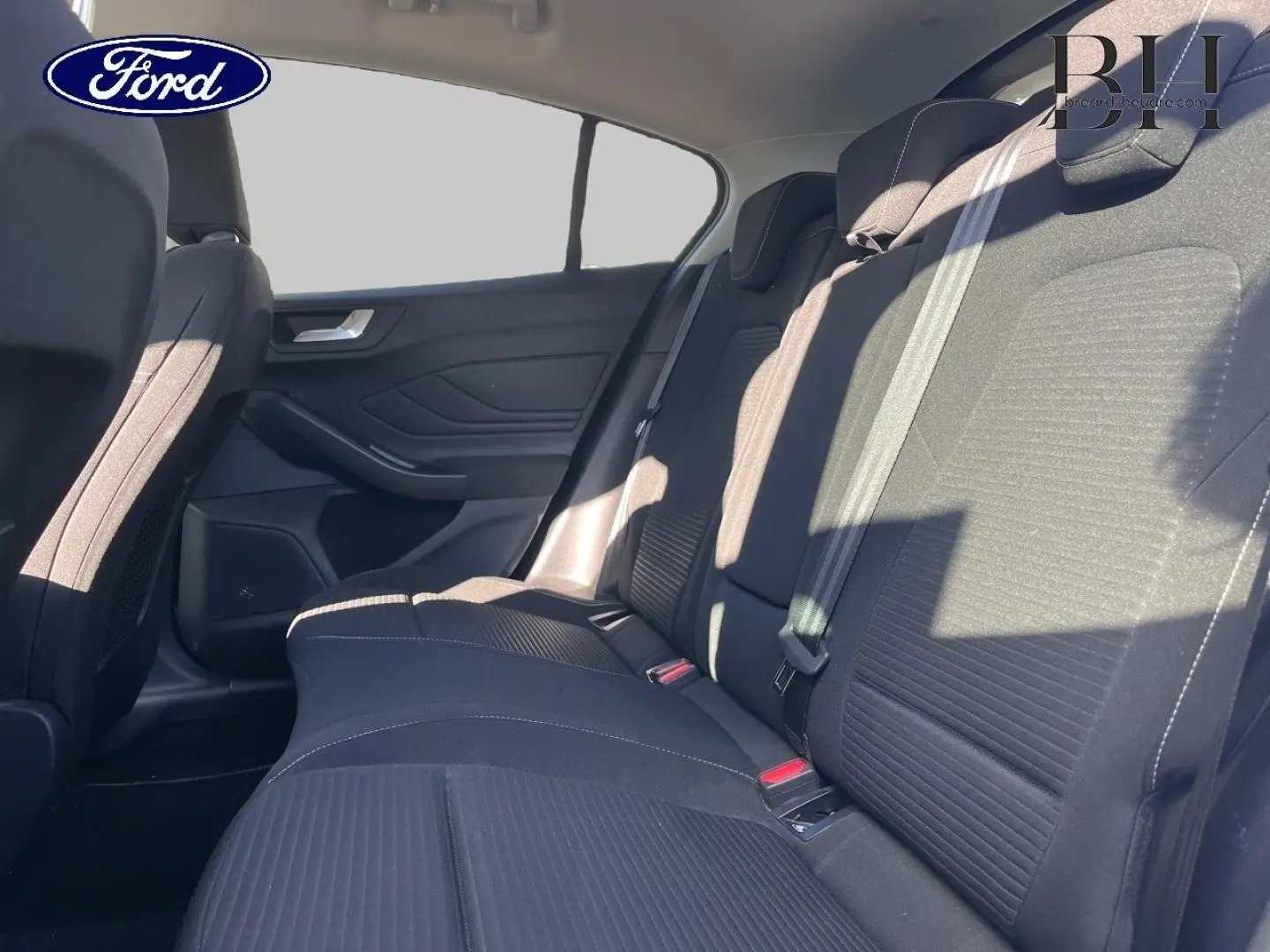 Vue latérale droite de la banquette arrière en tissu noir de la Ford Focus 2023, avec ceinture de sécurité visible.
