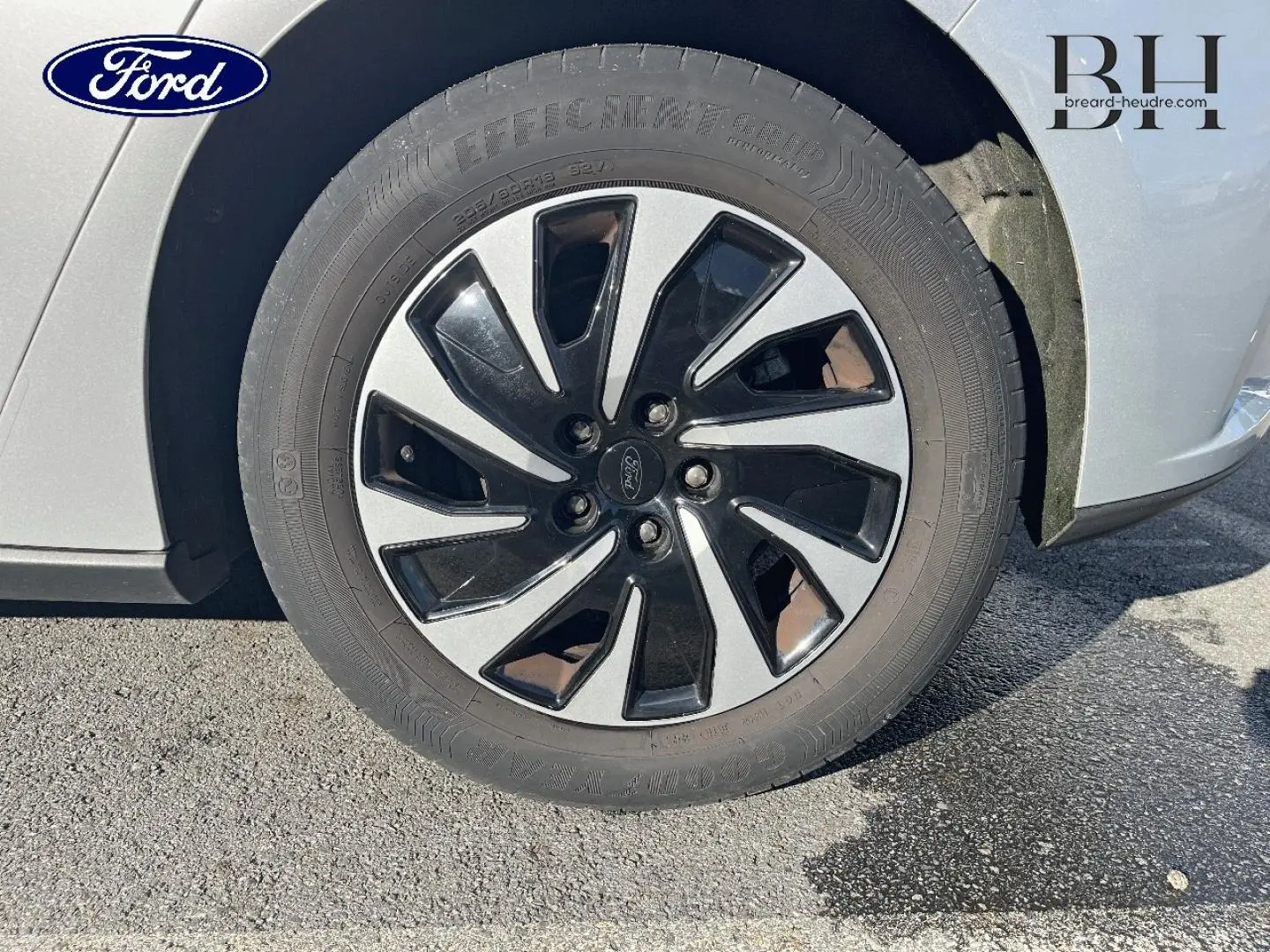 Gros plan sur la roue avant droite avec jante bicolore noir et gris d'une Ford Focus gris lunaire métallisé.
