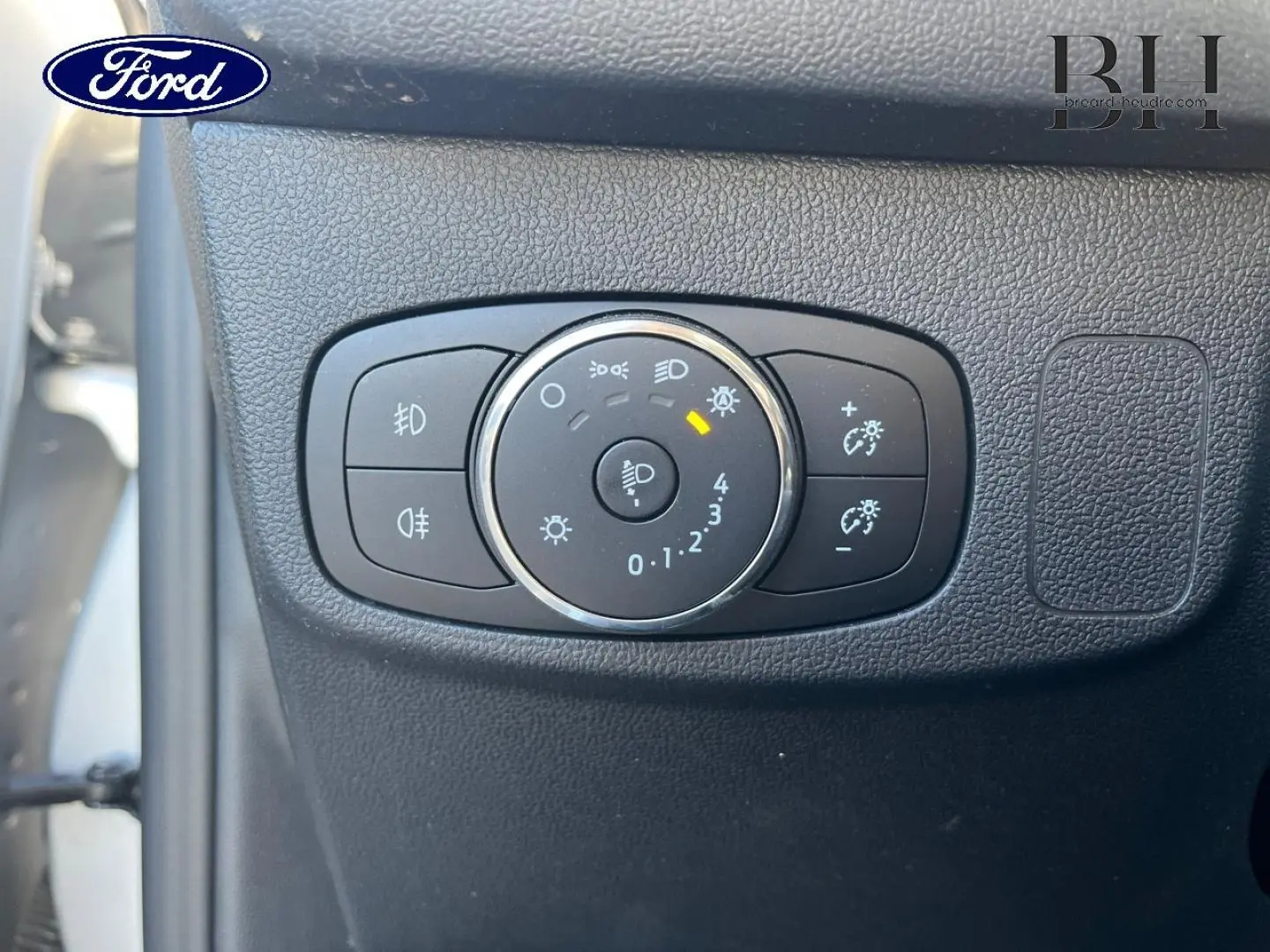 Gros plan sur le sélecteur d’éclairage noir intégré au tableau de bord de la Ford Focus gris lunaire 2023.