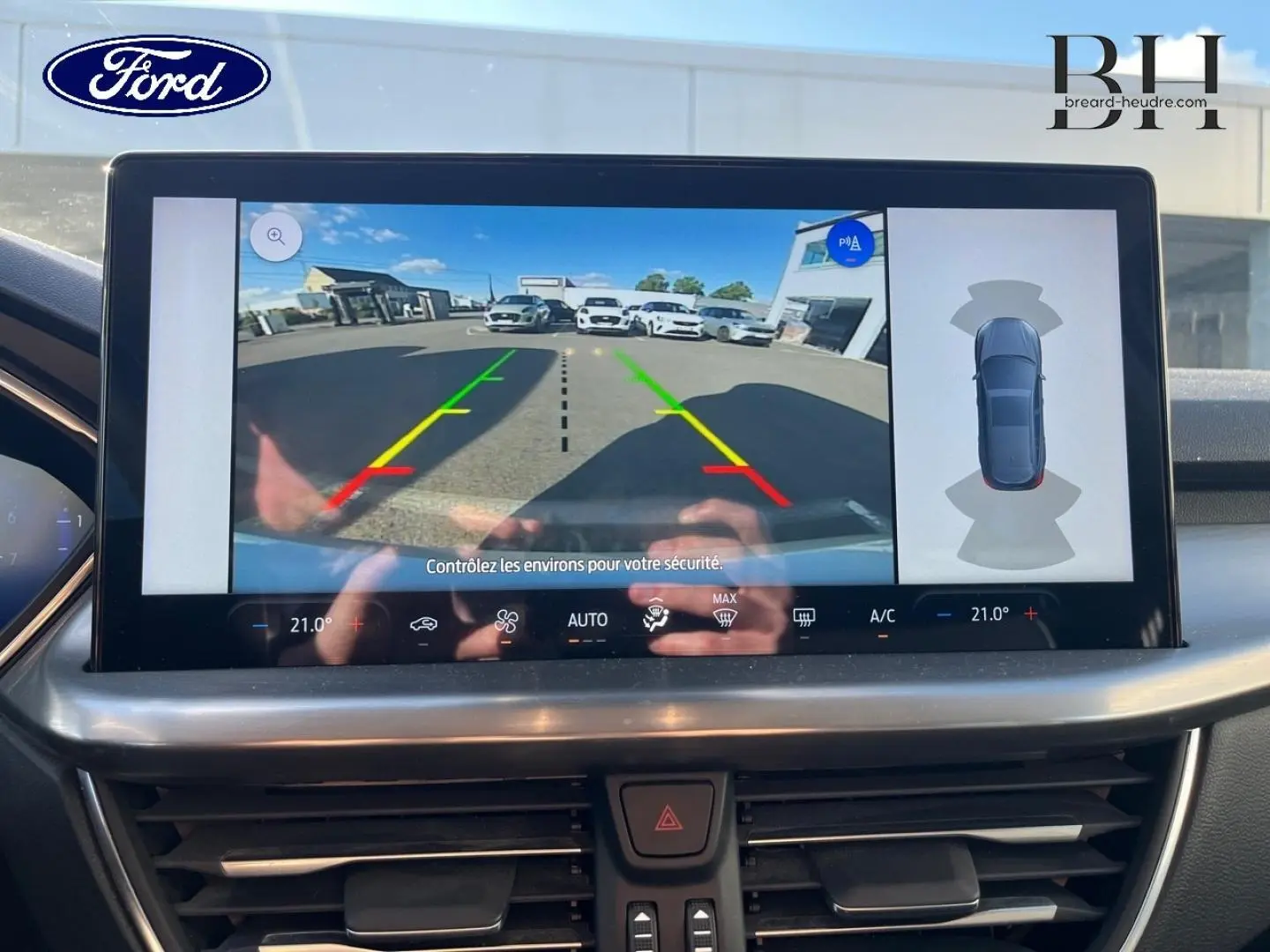 Écran tactile intérieur montrant la caméra de recul et l’aide au stationnement de la Ford Focus gris lunaire 2023.