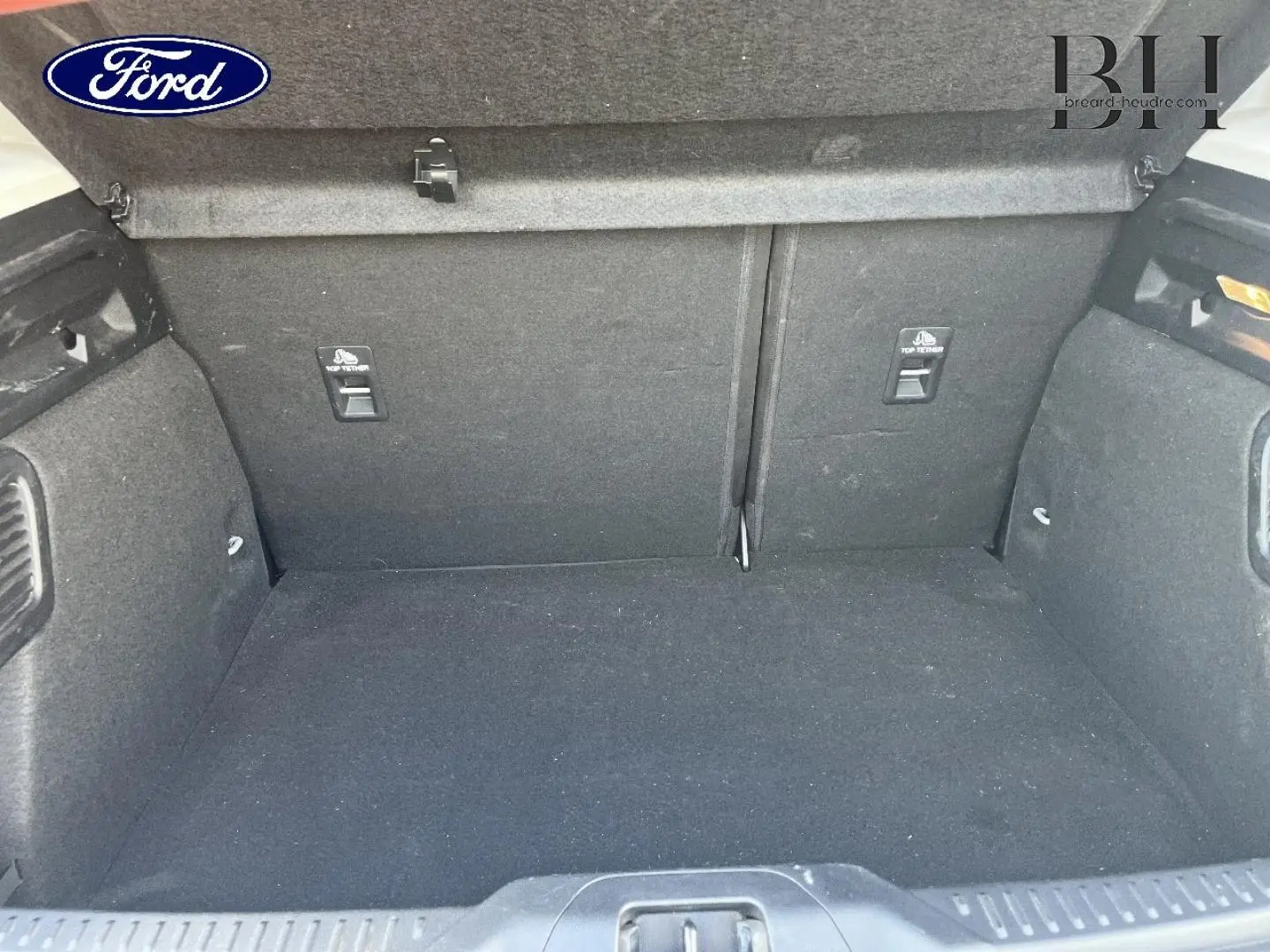Coffre vide vu de face d’une Ford Focus 2023 gris lunaire, intérieur tissu noir avec fixations ISOFIX.