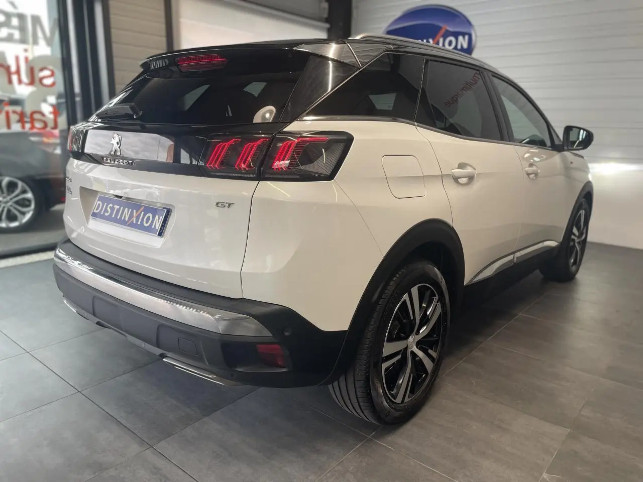 Vue 3/4 arrière droite du Peugeot 3008 GT blanc nacré avec toit noir et jantes alliage bi-ton.