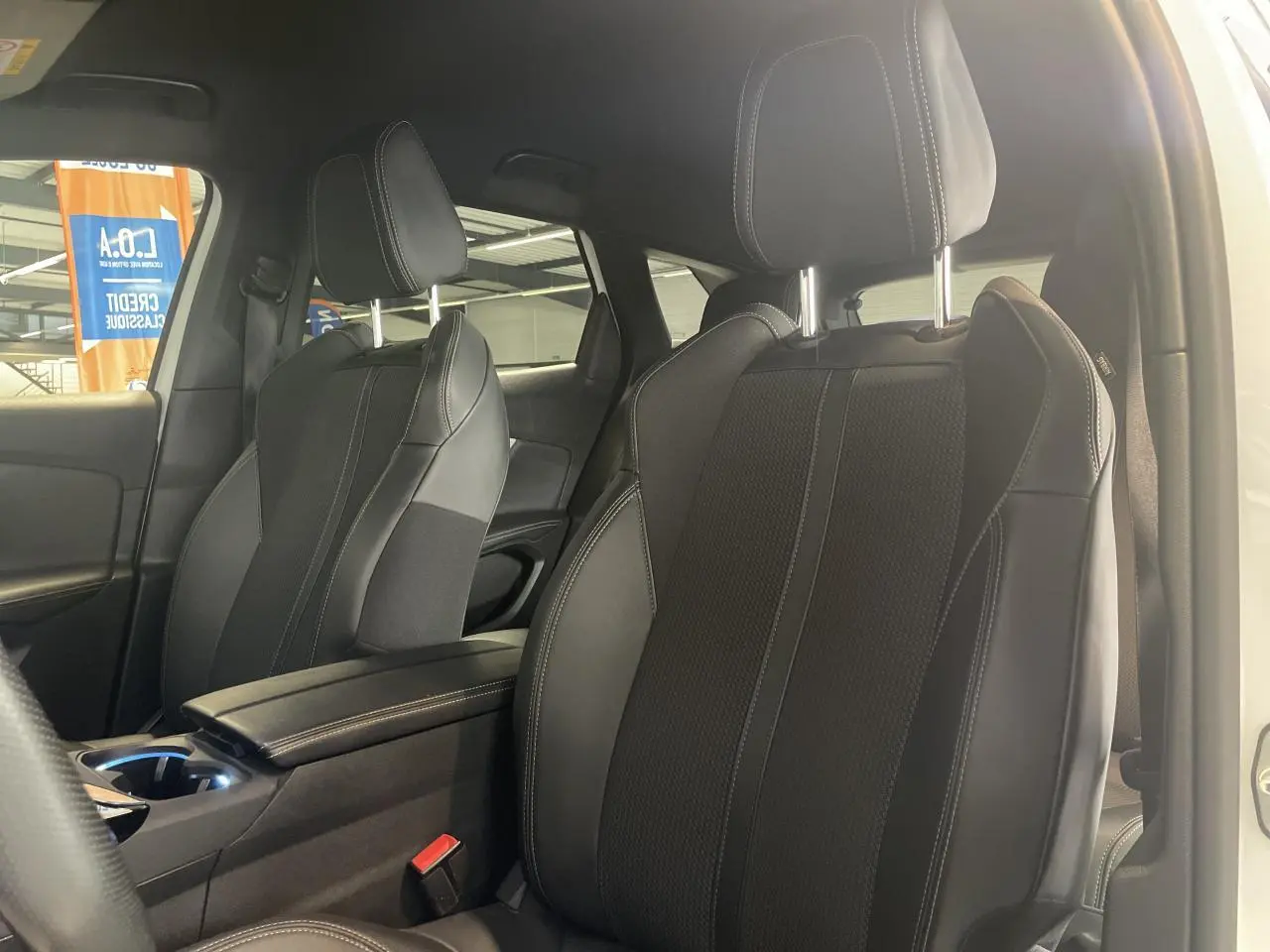 Vue intérieure côté droit des sièges avant en cuir noir avec surpiqûres blanches du Peugeot 3008 GT blanc nacré 2022.