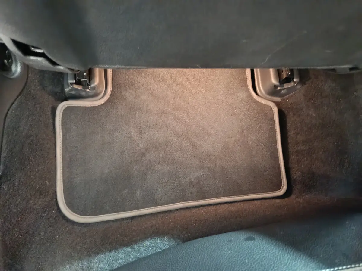 Tapis de sol noir sous le siège avant d’un Mercedes GLA 200 d Business Executive gris clair, vue intérieure basse.