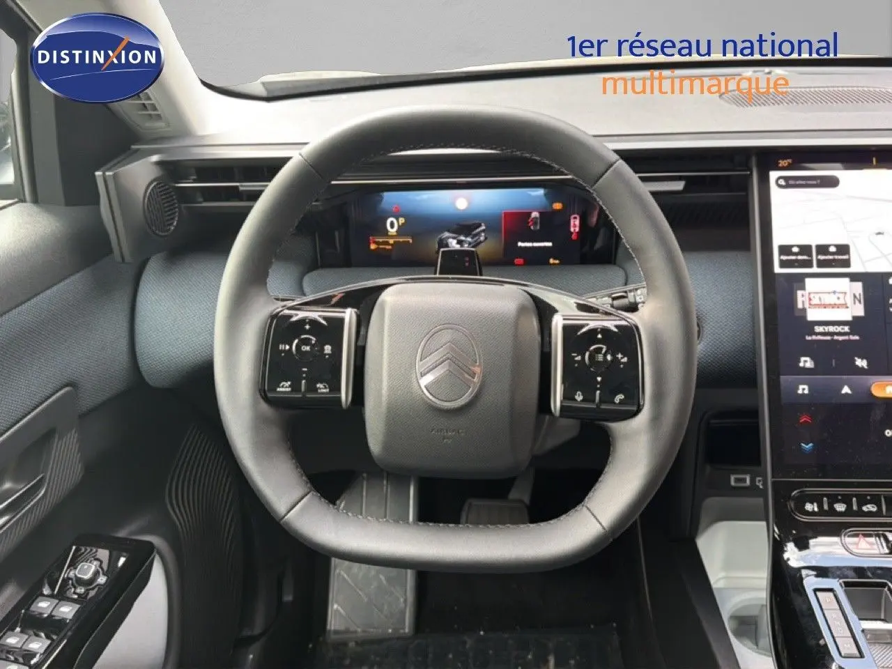 Vue intérieure centrée sur le volant cuir noir du Citroën C5 Aircross Hybrid avec tableau de bord numérique et écran tactile.