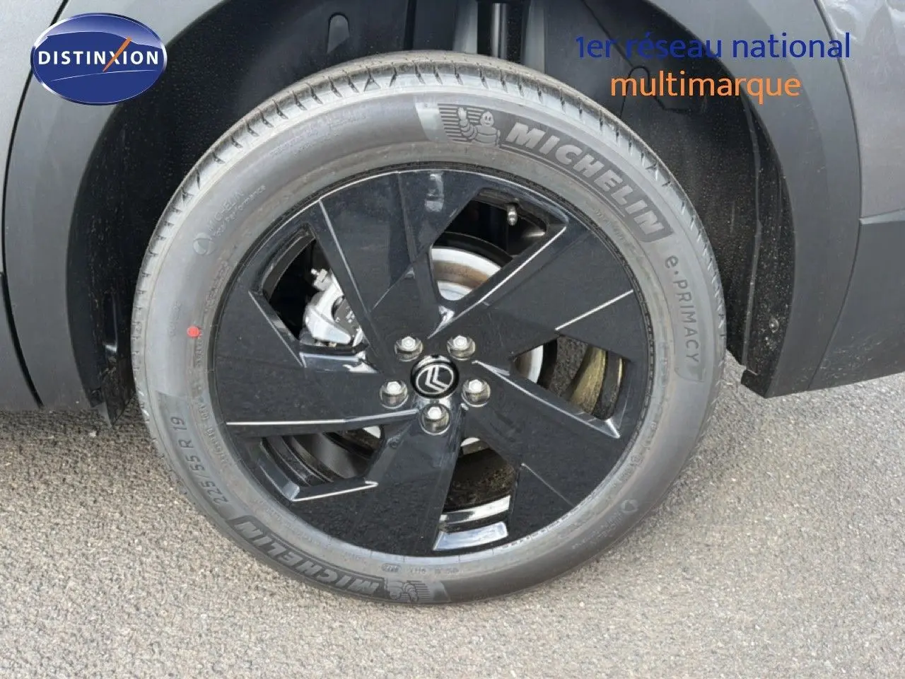 Gros plan sur la roue avant gauche du Citroën C5 Aircross Hybrid gris platinium avec jante noire brillante.