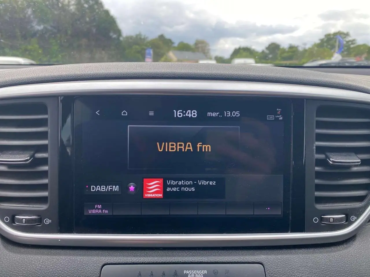 Écran tactile 8 pouces du Kia Sportage gris foncé, affichant la radio VIBRA fm en intérieur.