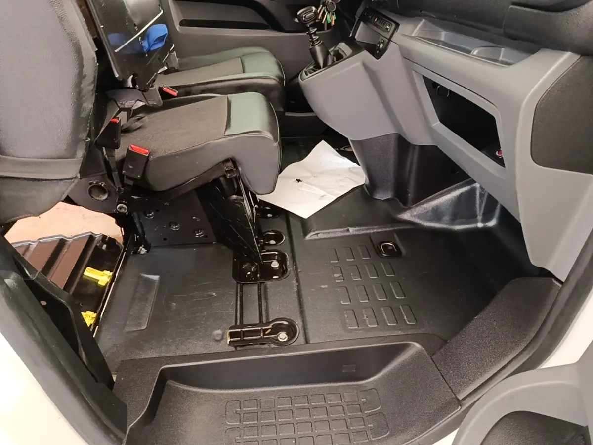 Vue intérieure côté passager avant du Peugeot Expert Fourgon 2020, montrant les sièges noirs et le plancher en caoutchouc.