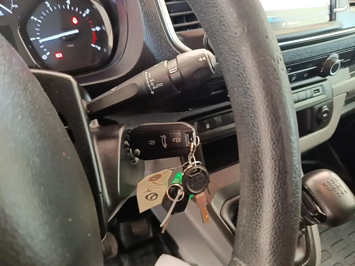 Vue intérieure côté conducteur du Peugeot Expert Fourgon blanc 2020, volant, clé de contact et levier de vitesse manuelle visibles.