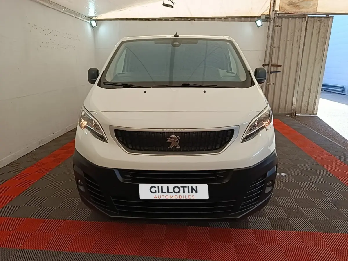 Vue avant d’un Peugeot Expert Fourgon blanc 2020 avec calandre noire et pare-chocs noir dans un garage.
