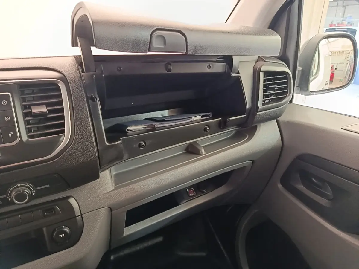 Intérieur du Peugeot Expert Fourgon blanc, vue côté passager sur la boîte à gants ouverte et la console avant.