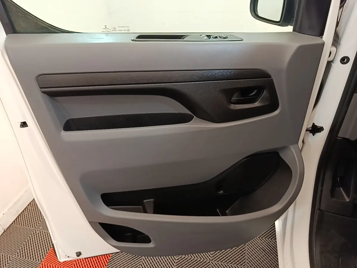 Vue intérieure de la porte avant gauche blanche du Peugeot Expert Fourgon 2020 avec commandes électriques et rangements intégrés.