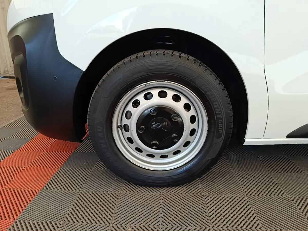 Gros plan sur la roue avant gauche acier du Peugeot Expert Fourgon blanc, avec pare-chocs noir mat visible.