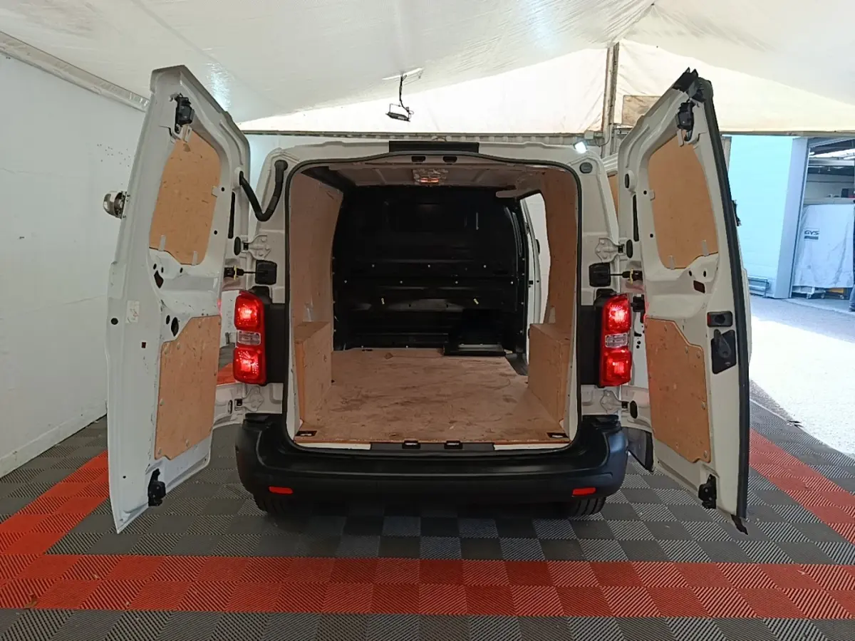 Vue arrière du Peugeot Expert Fourgon blanc 2020 avec portes ouvertes dévoilant l'espace de chargement en bois.