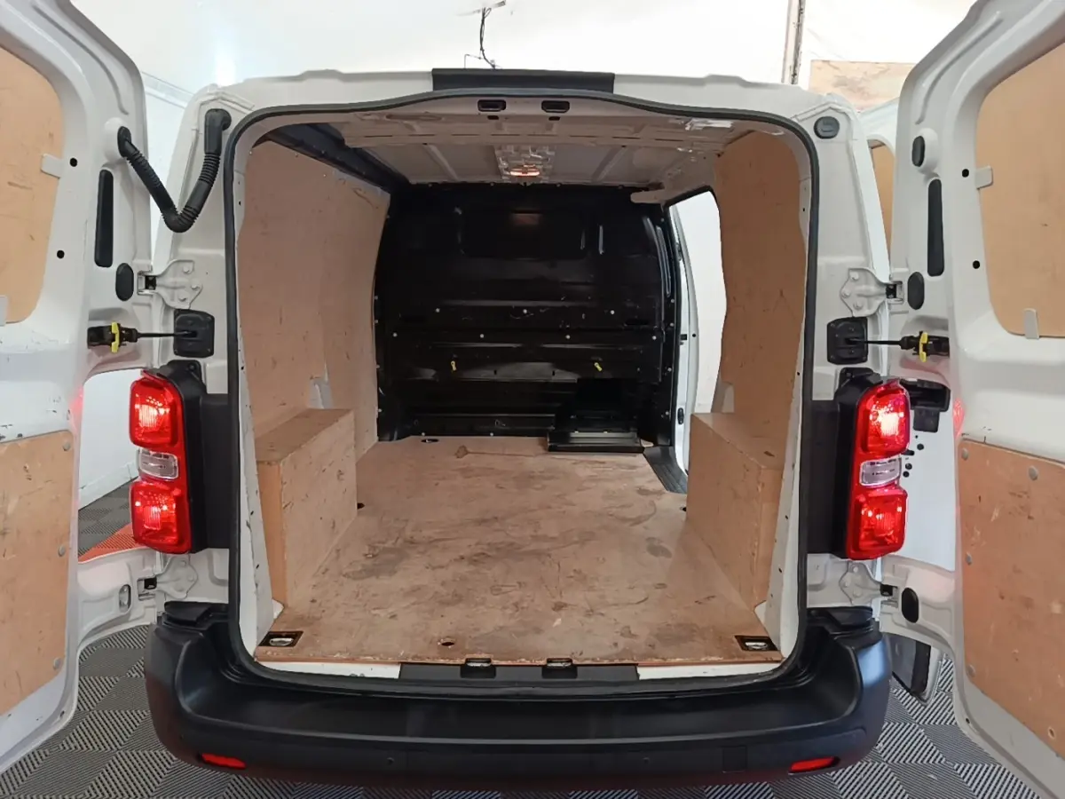 Vue arrière ouverte du Peugeot Expert Fourgon blanc 2020 montrant l'espace de chargement avec cloison pleine en bois.